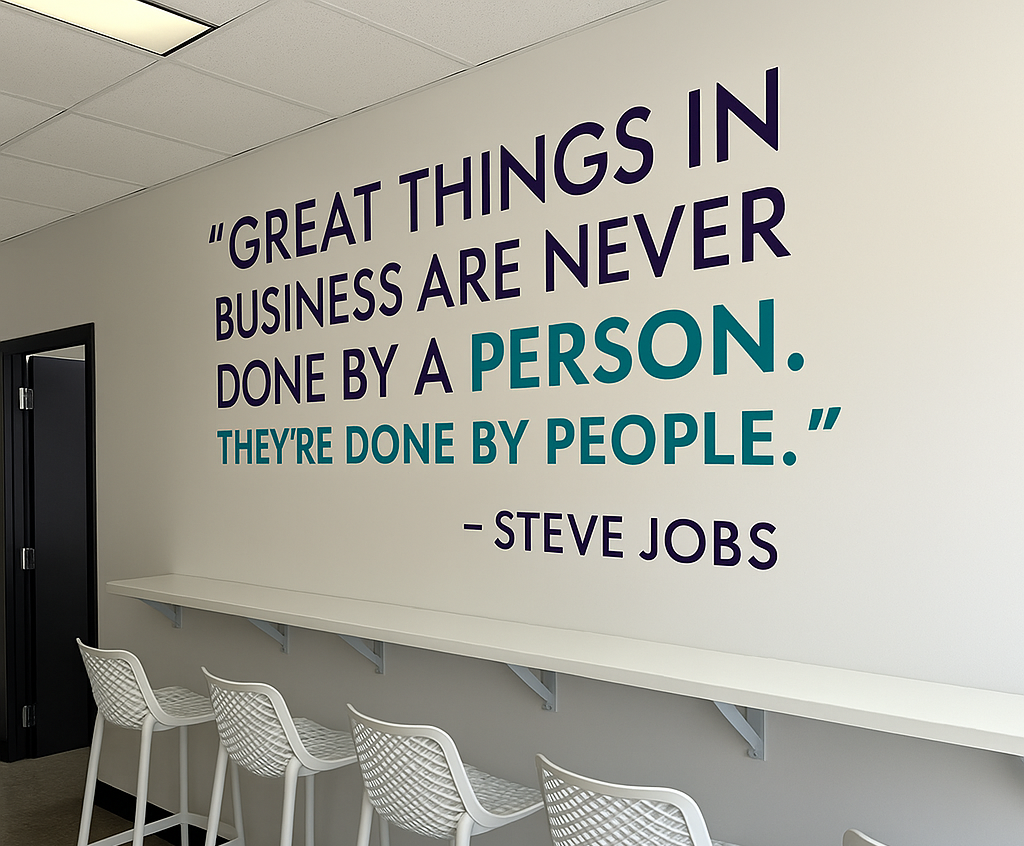 A white wall with a quote by Steve Jobs in blue and teal,