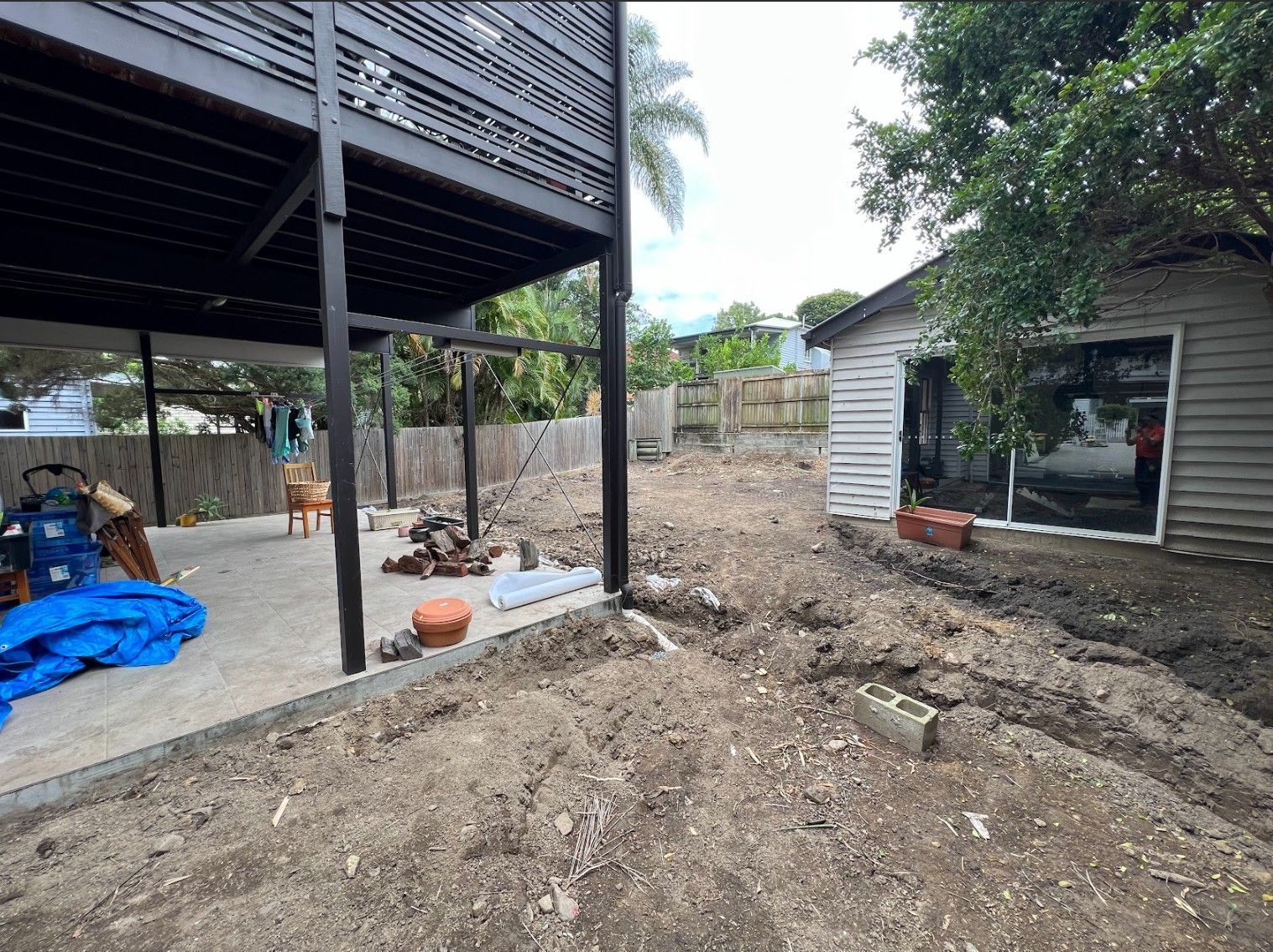 Backyard under construction with elevated dwelling during a raise and build under