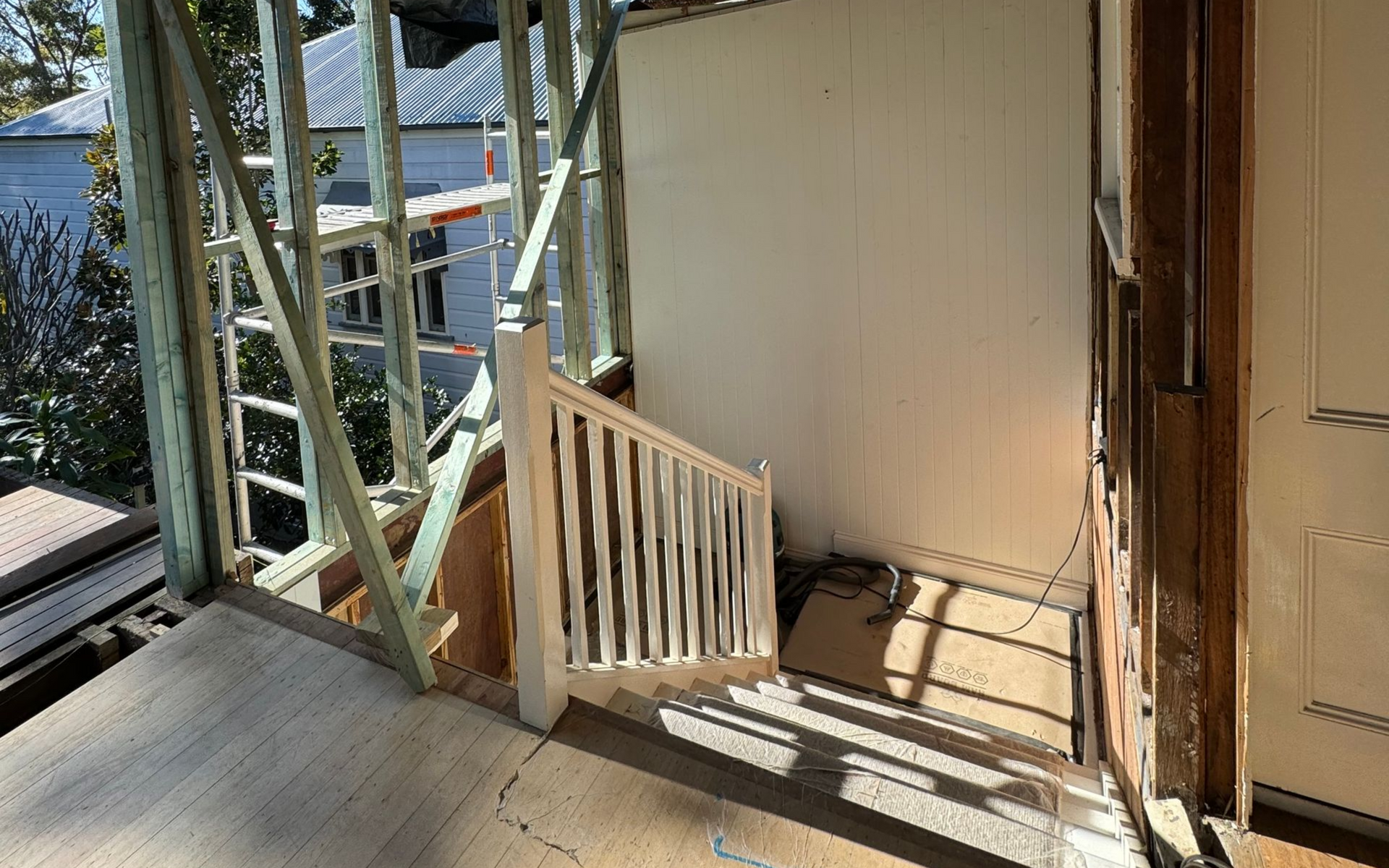 Timber staircase with white railing during the Bardon renovation